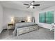 Cozy bedroom features neutral walls, a ceiling fan, carpet, and a large window with natural light at 3402 Devoe Ct, Marietta, GA 30062