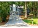 Exterior shot of home with two-car garage and a long driveway, nestled among mature trees and well-maintained landscaping at 3402 Devoe Ct, Marietta, GA 30062