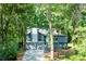 Home's inviting front exterior with two-car garage, lush trees, and well-manicured yard offers great curb appeal at 3402 Devoe Ct, Marietta, GA 30062