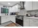 Modern kitchen featuring white cabinets, stainless steel appliances, and eye-catching backsplash design at 3402 Devoe Ct, Marietta, GA 30062