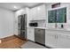 Bright, open kitchen with stainless steel appliances, white cabinets, and hardwood floors at 3402 Devoe Ct, Marietta, GA 30062