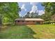 Large backyard featuring a brick home, lush green grass, and mature shade trees at 434 Terrace Sw Dr, Smyrna, GA 30082