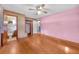 Spacious pink bedroom with hardwood floors and view into full bath at 434 Terrace Sw Dr, Smyrna, GA 30082