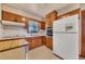 Traditional eat-in kitchen with wood cabinets, white appliances, gas range, and double basin sink at 434 Terrace Sw Dr, Smyrna, GA 30082