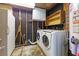 Utility room with black walls and open utilities, including washer, dryer, and water heater at 434 Terrace Sw Dr, Smyrna, GA 30082