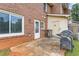 Back patio featuring brick exterior, grill, and access door, ideal for outdoor entertaining at 4691 Shumate Dr, Stone Mountain, GA 30083