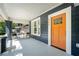 Inviting front porch with a seating area and a vibrant orange front door with large window for natural light at 943 Rose Sw Cir, Atlanta, GA 30310