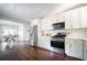 Bright kitchen with stainless steel appliances, white cabinets, stone countertops and hardwood flooring at 943 Rose Sw Cir, Atlanta, GA 30310