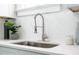 Close up of the kitchen sink, faucet and stone countertops with a modern backsplash at 943 Rose Sw Cir, Atlanta, GA 30310