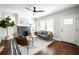 Bright living room featuring hardwood floors, a modern ceiling fan, and a cozy fireplace with contemporary furniture at 943 Rose Sw Cir, Atlanta, GA 30310