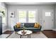 Living room featuring hardwood floors, large windows for natural light, and stylish decor for a cozy atmosphere at 943 Rose Sw Cir, Atlanta, GA 30310