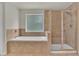 Bathroom featuring soaking tub, glass enclosed shower and tile flooring at 1354 Slate Bend Dr, Dacula, GA 30019