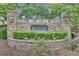 Stone community entrance sign amidst flowering bushes and manicured landscaping at 1354 Slate Bend Dr, Dacula, GA 30019