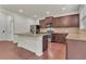 An open-concept kitchen boasts stainless steel appliances, dark cabinetry, and an island with granite countertops at 1354 Slate Bend Dr, Dacula, GA 30019