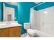 Second bathroom with blue walls, toilet, vanity, and tub/shower combo at 139 W Oaks Pl, Woodstock, GA 30188