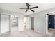 Bright bedroom features carpet, a ceiling fan, and a mirrored closet, connecting to the bathroom at 139 W Oaks Pl, Woodstock, GA 30188