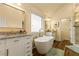 Bright bathroom featuring a soaking tub, double vanity with granite countertop and elegant gold fixtures at 2602 Corey Park Dr, Loganville, GA 30052