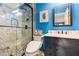 Renovated bathroom with a modern shower, sleek vanity, and blue accent walls at 2602 Corey Park Dr, Loganville, GA 30052