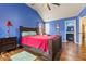 This bedroom features blue walls, hardwood floors, and adjacent bathroom at 2602 Corey Park Dr, Loganville, GA 30052