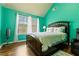 Bright bedroom with large windows, wood floors, and a decorative quilt on the bed at 2602 Corey Park Dr, Loganville, GA 30052