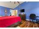 This bedroom features blue walls, hardwood floors, ceiling fan, and attached office space at 2602 Corey Park Dr, Loganville, GA 30052