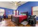 Bedroom with blue walls, hardwood floors, ceiling fan, and office area at 2602 Corey Park Dr, Loganville, GA 30052