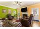 Cozy living room with fireplace, comfortable leather seating, ceiling fan, and hardwood floors at 2602 Corey Park Dr, Loganville, GA 30052