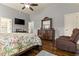 This main bedroom features hardwood floors, a ceiling fan, and an elegant wooden dresser with mirror at 2602 Corey Park Dr, Loganville, GA 30052