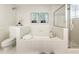 Bright bathroom featuring a soaking tub, glass-enclosed shower, white tile and neutral décor at 273 12Th Ne St # 111, Atlanta, GA 30309