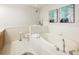 Bright bathroom featuring a soaking tub, white tile, and neutral décor at 273 12Th Ne St # 111, Atlanta, GA 30309