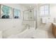 Bright bathroom featuring a soaking tub, glass-enclosed shower, white tile and neutral décor at 273 12Th Ne St # 111, Atlanta, GA 30309
