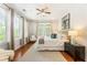 Bright bedroom with hardwood floors, neutral walls, ceiling fan, and three windows for natural light at 273 12Th Ne St # 111, Atlanta, GA 30309