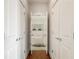 Hallway with white doors leading to the a full bathroom featuring a tub and tiled walls at 273 12Th Ne St # 111, Atlanta, GA 30309