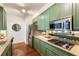 Galley kitchen featuring sage cabinetry, granite countertops, stainless appliances, and dark hardwood floors at 273 12Th Ne St # 111, Atlanta, GA 30309