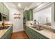 Galley kitchen featuring sage cabinetry, granite countertops, stainless appliances, and a view to the living room at 273 12Th Ne St # 111, Atlanta, GA 30309