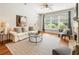 Bright living room featuring hardwood floors, a fireplace, large windows and comfortable seating options at 273 12Th Ne St # 111, Atlanta, GA 30309