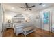 Bedroom with wood floors, ceiling fan, shiplap accent wall, and a view of lush landscaping at 4442 Academy St, Acworth, GA 30101