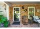 Cozy front porch showcasing brick accents, outdoor decor, a glass front door, and a relaxing seating area at 4442 Academy St, Acworth, GA 30101