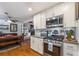Well-lit kitchen with stainless steel appliances, white cabinets, and an open layout leading into the dining area at 4442 Academy St, Acworth, GA 30101