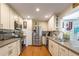 Galley kitchen featuring stainless steel appliances, granite countertops, and white cabinetry at 4442 Academy St, Acworth, GA 30101