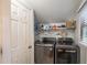 Convenient laundry room with modern washer and dryer units and ample storage shelves at 4442 Academy St, Acworth, GA 30101