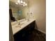 Bathroom featuring double sinks with dark cabinetry, a large mirror, and decorative flooring at 713 Trickum Valley Dr, Woodstock, GA 30188