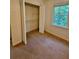 Bedroom featuring a window, closet with bi-fold doors, and neutral carpet at 713 Trickum Valley Dr, Woodstock, GA 30188