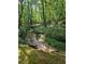 Picturesque backyard creek and lush, wooded surroundings create a peaceful outdoor space at 713 Trickum Valley Dr, Woodstock, GA 30188