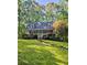 Charming cottage-style home featuring a lush, green lawn and mature trees for added privacy at 713 Trickum Valley Dr, Woodstock, GA 30188
