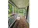 Covered porch with stained wood flooring and overlooking a lush treed yard at 713 Trickum Valley Dr, Woodstock, GA 30188