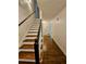 Interior view of the staircase with hardwood steps and a black handrail, leading to the upper level at 713 Trickum Valley Dr, Woodstock, GA 30188