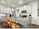 Beautiful kitchen featuring gray cabinets, stainless steel appliances, granite counters, and a central island with barstool seating at 942 Elwood St, Dacula, GA 30019
