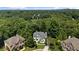 Aerial view showcases the stunning white house nestled amongst a beautiful and lush forest at 135 Emerald Ln, Roswell, GA 30075