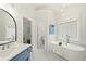Serene bathroom featuring a soaking tub, white marble floors, and a modern vanity at 135 Emerald Ln, Roswell, GA 30075